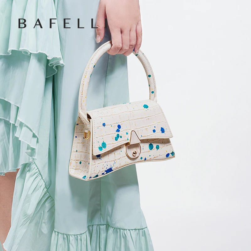 Handbag with blue and green speckles held by a person wearing a light blue dress, with 'BAFELL' branding.